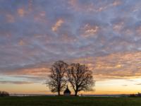 Auch über der Kriegergedächtniskapelle Hittenkirchen geht die Wolkenfärbung in orangegelb über
